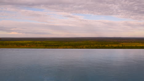Man-jumping-into-infinity-pool-of-resort-in-Serengeti,-Tanzania