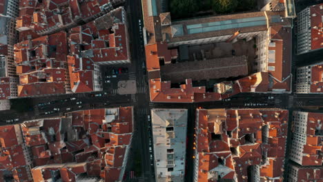 Top-down-drone-shot-over-red-rooftops-European-City-at-sunset-Lyon-France