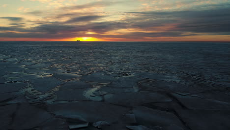Aerial-backward-movement-shot-over-the-melting-arctic-sea-ice-floes-breaking-up-taking-place-in-the-sea
