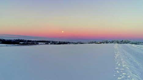 Aerial-flyover-soft-snowy-winter-landscape-and-lighting-full-moon-on-pink-sky-in-the-morning---Magnificent-white-wonderland-scenery-in-nature