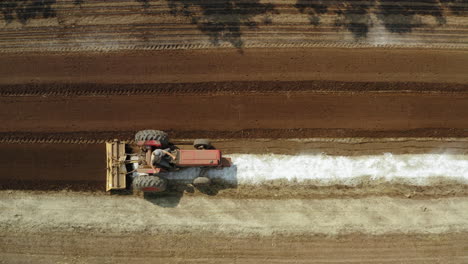 Tractor-Mezclando-Fertilizante-Con-La-Tierra-De-Cultivo,-Toma-Aérea-De-Drones-De-La-Máquina-De-Enmienda-En-El-Campo