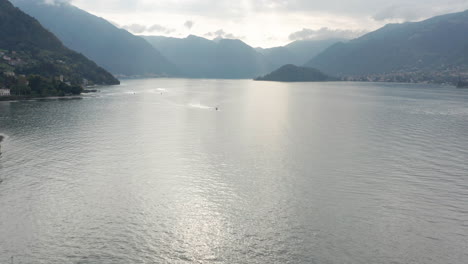 Drohne,-Die-Auf-Einem-Riesigen-Und-Wunderschönen-See-Auf-Ein-Fernes-Boot-Zufliegt