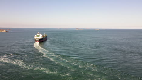 Aerial-shot-of-a-fuel-tanker-leaving-harbor,-with-tugboat-manoeuvring-away
