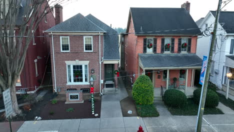 Rising-aerial-of-homes-in-town-decorated-for-Christmas