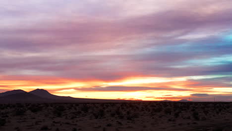 Un-Cielo-Increíblemente-Colorido-Sobre-El-Desierto-De-Mojave-Mientras-El-Sol-Poniente-O-Naciente-Ilumina-Las-Nubes---Vista-Panorámica-Deslizante