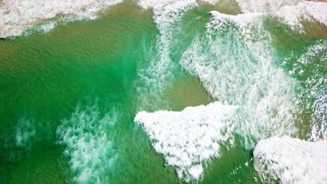 Aerial:-Drone-shot-over-the-ocean-tilting-up-to-reveal-a-sandy-beach-coastline-near-Byron-Bay,-Australia