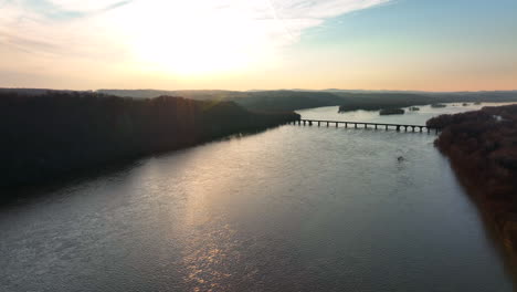 Beautiful-nature-pullback-reveal-of-bridge-across-wide-river-at-sunrise
