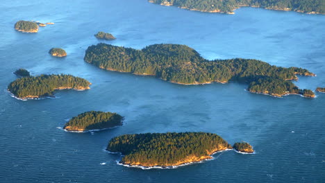 Small-Pine-Tree-Forested-Islands-in-the-Ocean,-Aerial-View-Golden-Hour