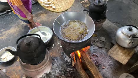 The-process-of-cooking-fried-foods-such-as-tofu,-tempeh-in-a-traditional-skillet-and-stove-using-coals-and-a-stove-2