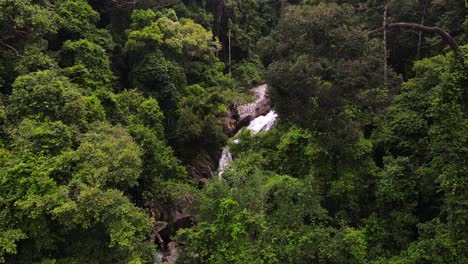 Drone-captures-the-beautiful-Than-Sadet-waterfall-covered-in-trees-and-lush-green-setting-of-Koh-Phangan,-Thailand