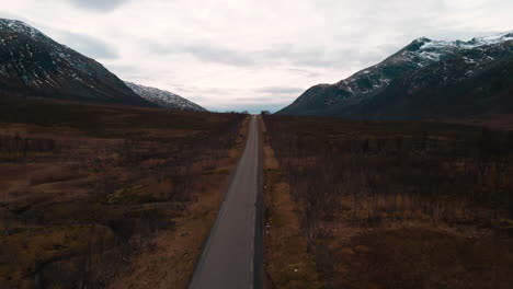 Road-along-hostile-landscape-on-Kvaloya,-Northern-Norway,-drone-view