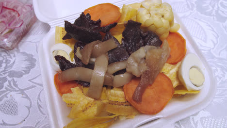 Close-up-of-Peruvian-dish-"Carne-seca"-or-biltong-with-chifles,-camote-and-"maiz"