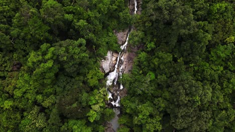 Drone-aerial-camera-flying-along-a-mountain,-waterfall,-and-rainforest-in-Thailand's-evergreen-Koh-Phangan-island-region