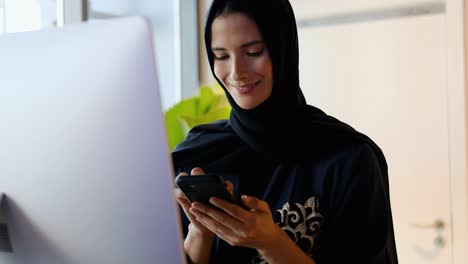 Woman-wearing-Hijab-Abaya-using-smart-mobile-cell-phone