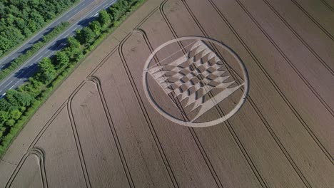Aerial-video-of-crop-circles-in-a-field-of-yellow-grain-in-the-UK's-Micheldever-Station-are-captured-by-drone-with-nearby-traffic