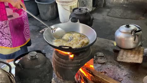 The-process-of-cooking-fried-foods-such-as-tofu,-tempeh-in-a-traditional-skillet-and-stove-using-coals-and-a-stove