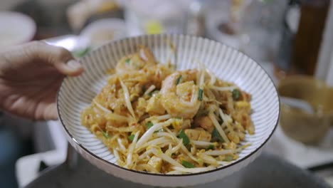 Puting-Pad-Thai-from-the-pan-into-dish-ready-to-eat
