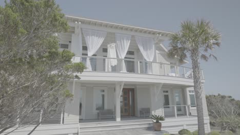 Idyllic-white-wood-built-two-story-beachfront-property,-Slider-shot-tracking-right