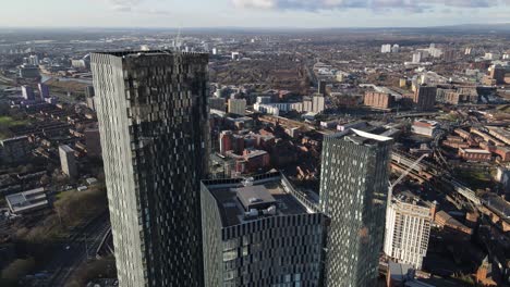 4K-60FPS-Aerial-drone-flight-in-Manchester-City-Centre-overlooking-Elizabeth-tower-and-three-towers-with-Castlefield-and-a-building-under-construction-in-the-background