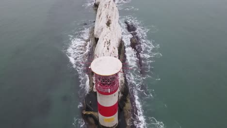 4K-30FPS-Aerial-drone-flight-passing-over-the-red-and-white-lighthouse-to-slowly-reveal-the-white-cliffs-of-The-Needles-on-the-coast-of-The-Isle-of-Wight
