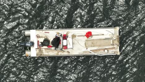 Überkopfaufnahme-Von-Fischern-Auf-Einem-Weißen-Fischerboot,-Das-In-Ruhigem-Wasser-Verankert-Ist