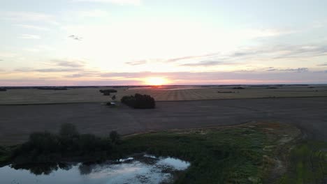 Sonnenuntergang-Im-Spätsommer-über-Weitläufigem-Ackerland-Und-Einem-Winzigen-See-Im-Ländlichen-Süden-Von-Alberta,-Kanada