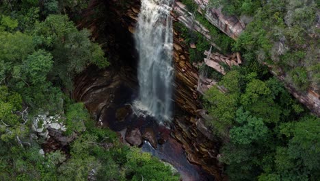Aerial-drone-shot-flying-above-the-incredible-Mosquito-Falls-surrounded-by-tropical-jungle-and-cliffs-in-the-Chapada-Diamantina-National-Park-in-Northeastern-Brazil-on-a-warm-sunny-summer-day