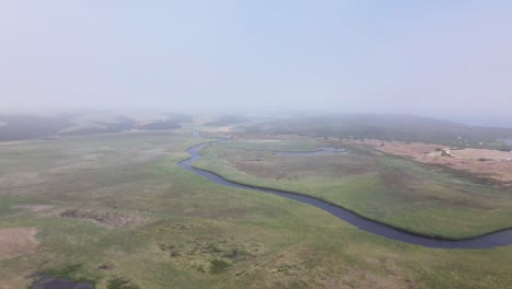 Drone-flight-over-a-meandering-river-in-the-marshlands