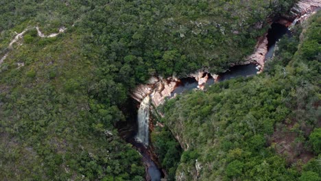 Aerial-drone-cinematic-shot-of-the-incredible-Mosquito-Falls-surrounded-by-tropical-jungle-and-cliffs-in-the-Chapada-Diamantina-National-Park-in-Northeastern-Brazil-on-a-warm-sunny-summer-day