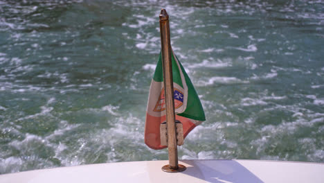 National-Flag-Of-Italy-As-Civil-Ensign-On-The-Back-Of-Boat-With-Backwash