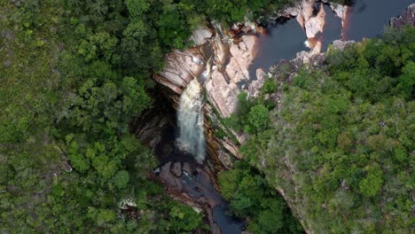 Aerial-drone-dolly-out-shot-of-the-incredible-Mosquito-Falls-surrounded-by-tropical-jungle-and-cliffs-in-the-Chapada-Diamantina-National-Park-in-Northeastern-Brazil-on-a-warm-sunny-summer-day
