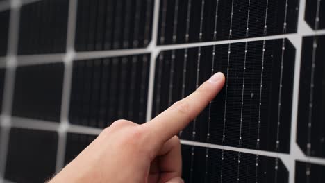 Finger-running-across-the-surface-of-a-solar-panel-checking-its-efficiency