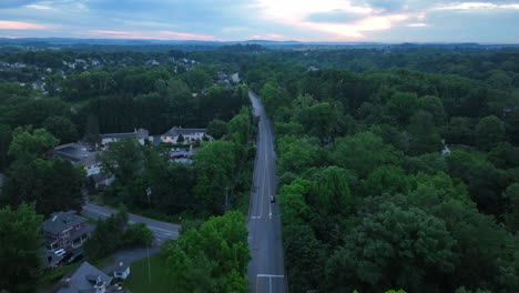 Aerial-shot-of-a-long,-straight-road-at-sunset
