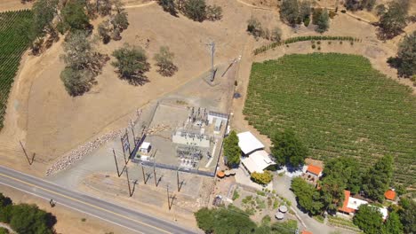 A-small-power-transmission-station-or-distribution-substation-in-a-rural-area-of-California-near-vineyards-and-foothills---aerial-view