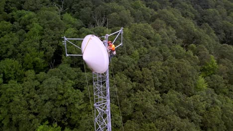 Workers-install-communications-dish-on-tower-aerial-near-in-sampson-nc,-north-carolina