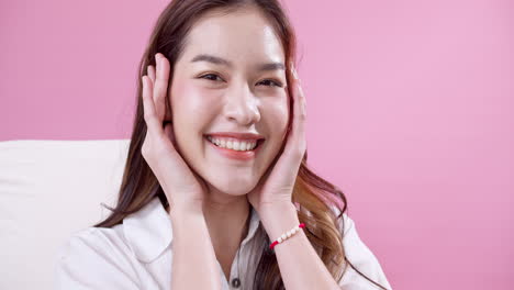 Beautiful-Asian-woman-vibrating-with-happiness-in-the-studio-with-pink-background