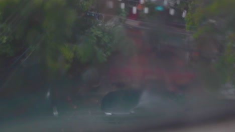 Eine-Filmische-Aufnahme-Einer-Nassen-Stadt-Durch-Die-Windschutzscheibe-Aus-Dem-Auto-Bei-Regenwetter