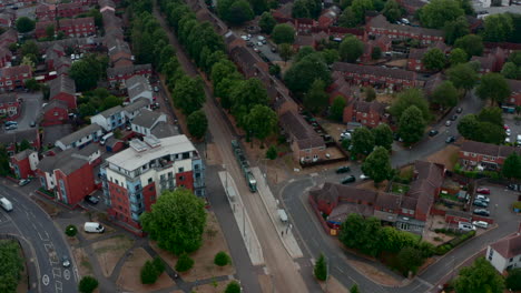 Drone-shot-of-Nottingham-city-tram-stopping-at-a-station