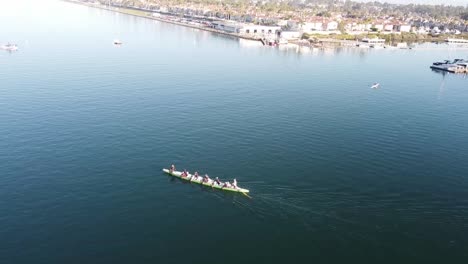 A-dragon-boat-paddle-across-the-water-channel,-aerial-view