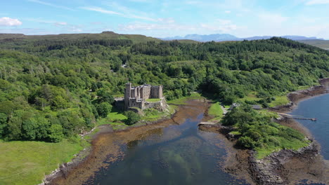Dunvegan-Castle,-captured-by-drone-in-a-smooth,-sweeping-shot-around-the-castle,-showing-the-stunning-scenery-surrounding-the-castle-as-well-as-the-magnificent-grounds