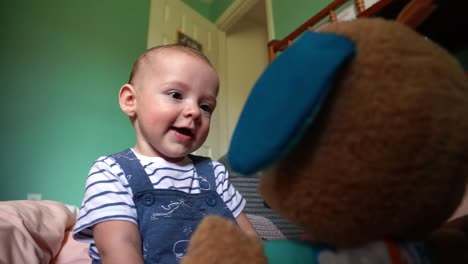6-Monate-Alter-Junge-Lacht-Und-Lächelt-Mit-Stofftier-Im-Kinderzimmer