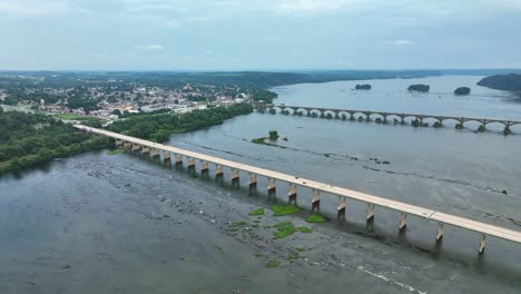 Two-bridges-crossing-over-the-Susquehanna-River-and-a-panning-view-towards-the-city-of-Columbia,-Pennsylvania