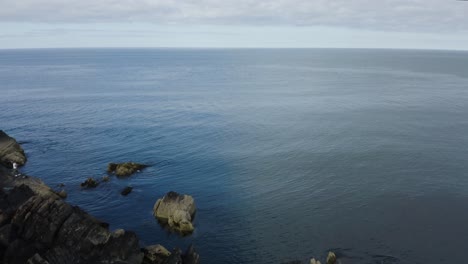 Die-Drohne-Fliegt-Entlang-Der-Felsigen-Küste-Von-Clogherhead,-Irland,-In-Richtung-Meer-1