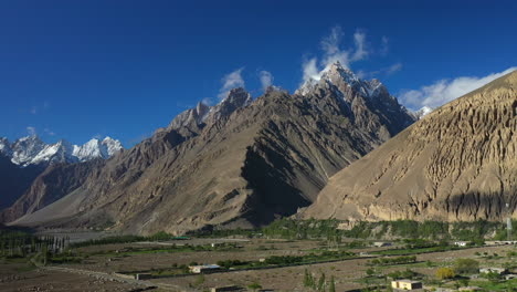 Cinematic-drone-shot-of-Tupopdan-Peak,-Passu-Cones-in-Hunza-Pakistan-snow-covered-mountain-peaks-with-steep-cliffs,-wide-aerial-shot-panning-to-reveal-mountain-range