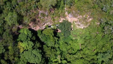 Toma-Aérea-De-Drones-Descendentes-De-La-Entrada-De-La-Cueva-Al-Pozo-Encantado-O-Poço-Encantado-Rodeado-De-árboles,-Plantas-Y-Acantilados-En-El-Parque-Nacional-Chapada-Diamantina-En-El-Norte-De-Brasil