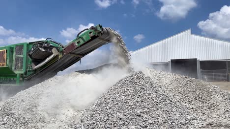 Crushed-rocks-and-concrete-coming-off-the-belt-of-a-rock-crusher-creating-huge-clouds-of-dust-1