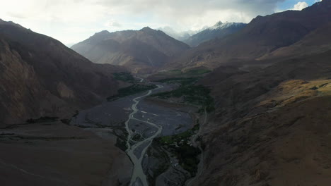 Cinematic-drone-shot-of-valley-below-Tupopdan-Peak,-Passu-Cones-in-Hunza-Pakistan,-wide-aerial-shot-slow-moving-with-the-Hunza-River