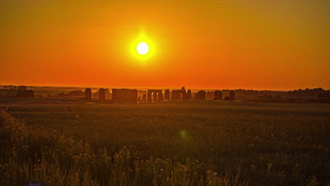 Timelapse-shot-of-tourists-walking-around-Smiltene-Stonehenge-during-evening-time-with-sun-setting-in-the-background