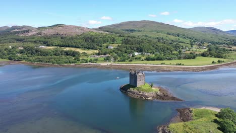 An-impressive-drone-shot-of-Castle-Stalker,-Scotland,-on-a-beautiful-summers-day