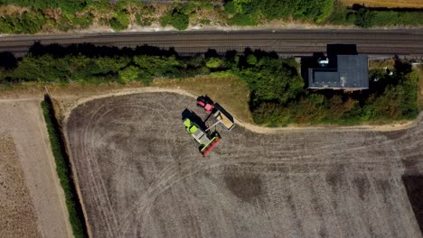 Aerial-footage-of-a-combine-harvester-feeding-produce-into-the-trailer-of-a-tractor